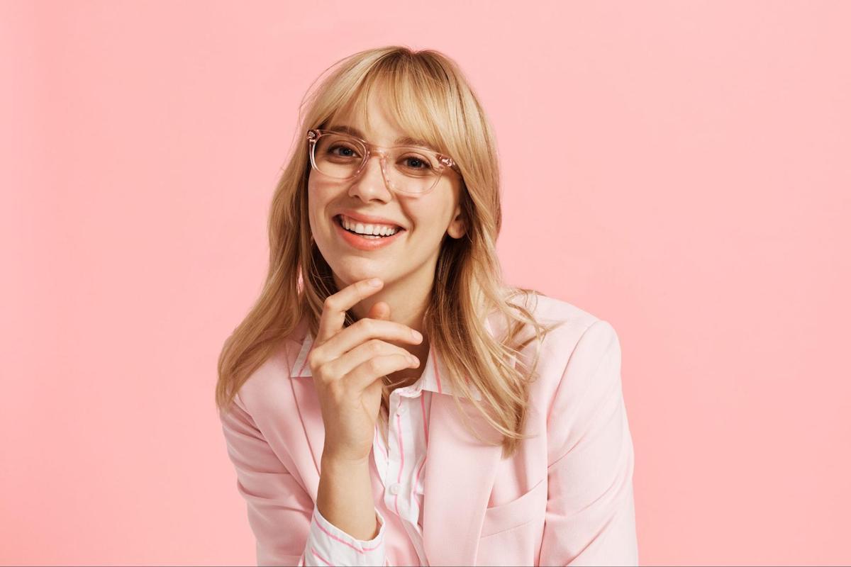 Trendy clear glasses frames: pretty woman smiling at the camera