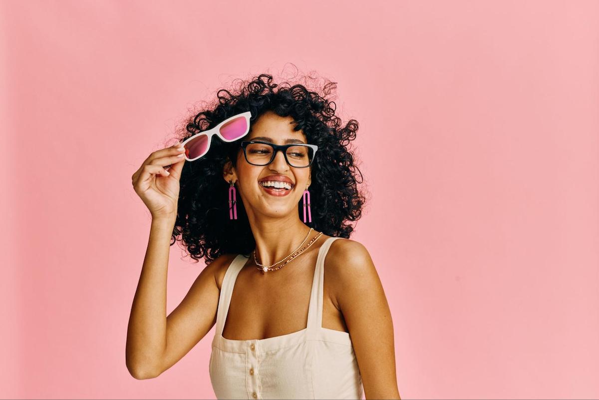 Woman holding a pair of rectangle glasses