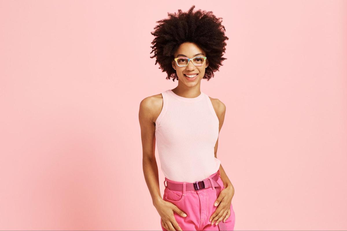 Narrow eyeglass frames: woman wearing a pink top and posing at the camera