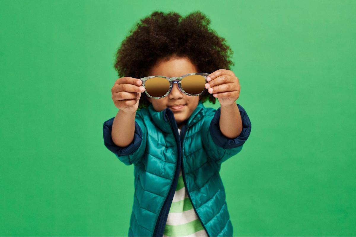 Kids sunglasses: kid holding a pair of eyeglasses